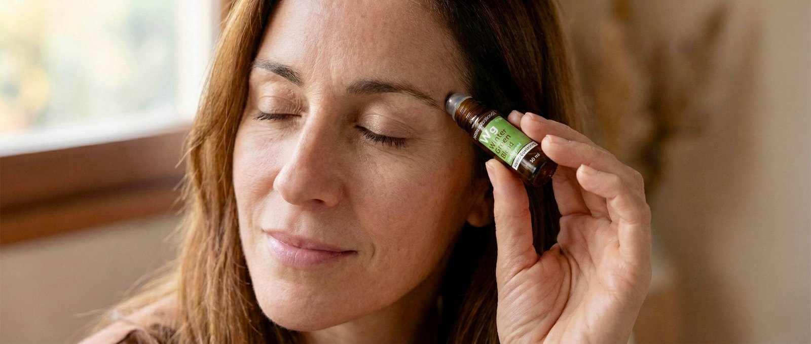 Mujer aplicándose Winter Green - Aceite Esencial Conie Bogart